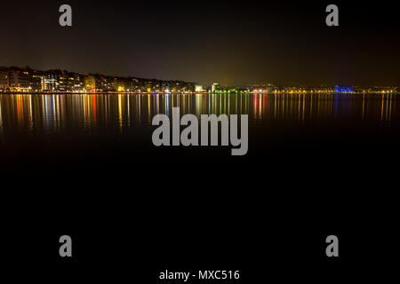 Thessaloniki, Griechenland, bunte lange Belichtung Foto der Stadt mit Blick auf den Hafen bei Nacht aus dem Dock. Stockfoto