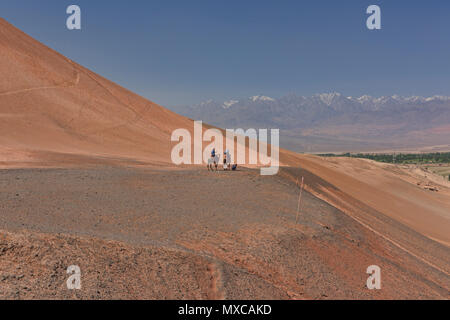 Camel Riders, Blick auf die Tian Shan, Flammenden Berge, Xinjiang, China Stockfoto