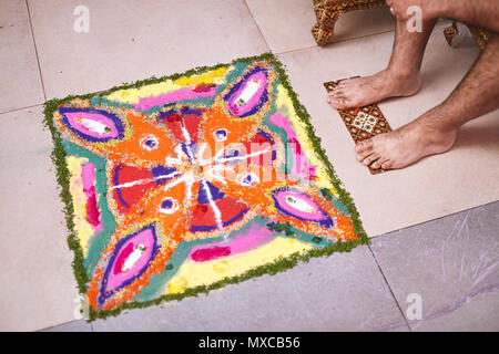 Die Füße der Bräutigam vor der traditionellen rangoli Kunst Dekoration aus der multi-color Reis und Sand während des traditionellen indischen Zeremonie vefo Stockfoto