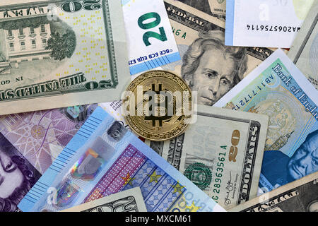 Bitcoin goldene Münze auf United States US twenty Dollar Bill (20 $), Großbritannien Pfund Sterling Banknoten und EU-Euro-banknoten. Stockfoto