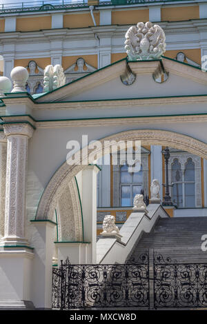 Auf der Suche durch weiße Gateway mit schwarzen schmiedeeisernen Toren Schritte und Teile der äußeren Senf Wände der Moskauer Kreml, Rüstkammer Gebäude Stockfoto