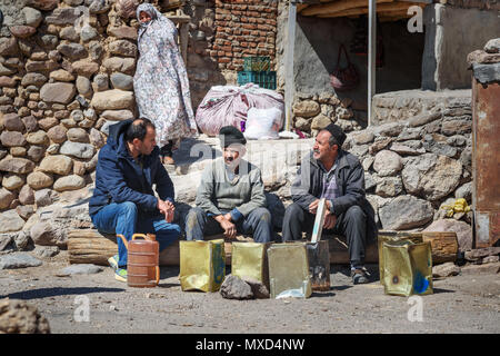 Kandovan, Osten der Provinz Aserbaidschan, Iran - 16. März 2018: Drei Iranische ältere Männer sitzen und sprechen Sie auf der Straße in Rock Dorf Kandovan Stockfoto