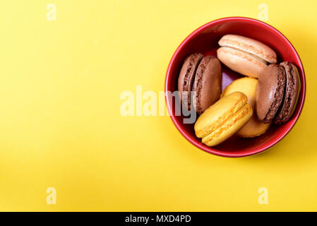 Bunte französische Macarons auf gelben Hintergrund. Stockfoto