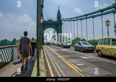 Verkehr und Fußgänger auf Hammersmith Suspension Bridge in London, UK. Stockfoto