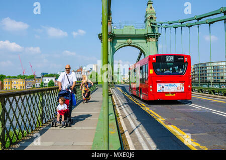 Verkehr und Fußgänger auf Hammersmith Suspension Bridge in London, UK. Stockfoto