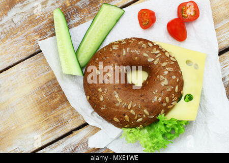 Braun Bagel mit Käse und Salat auf einer Papierserviette Schuß von der Oberseite Stockfoto