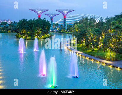 Spektakuläre Aussicht auf künstliche Bäume von Gärten durch die Bucht in Singapur in der Dämmerung Stockfoto