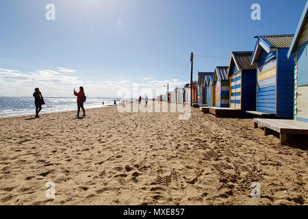 Brighton Beach, Australien: 31. März 2017: ein Tourist nimmt ein Foto seiner Freundin von den bunten Badekabinen am Strand von Brighton in Melbourne. Stockfoto