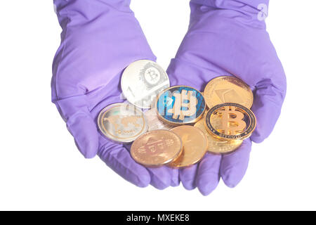 Hand in Lila Handschuh hält Bitcoins Crypto Währung auf weißem Hintergrund. Mining Konzept. Stockfoto