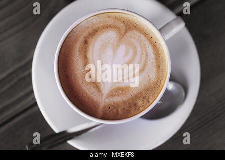 Tasse heißen Cappuccino auf einem Holztisch, Ansicht von oben Stockfoto