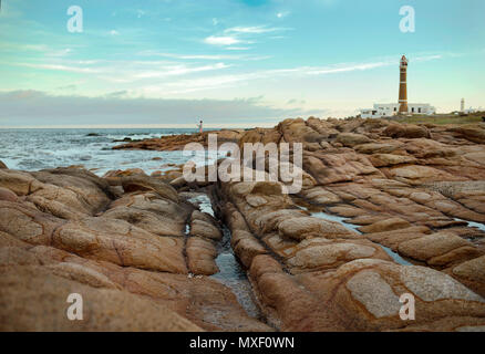 Die malerische Küste von Cabo Polonio mit seinen glatten Felsen und Leuchtturm im Hintergrund. UNESCO-Welterbe. Uruguay, Südamerika Stockfoto