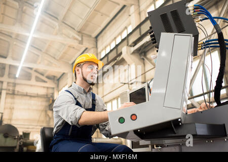 Maschinenbediener Eingehüllt in Arbeit Stockfoto