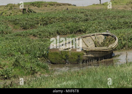 Küsten Szenen - noch Leben - ein kleines Ruderboot in der Nähe der Küste verlassen dem Verfall anheim. Essex, Großbritannien. Stockfoto
