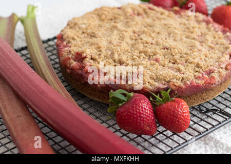 Eine köstliche Erdbeeren und Rhabarber crumble Slices, mit frischem Obst angezeigt. Hausgemachte und noch warm aus dem Ofen. Dieses Rezept ist glutenfrei. Stockfoto