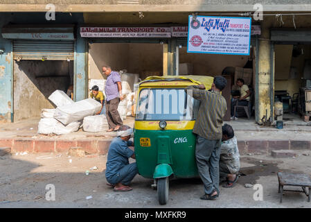 Drei Männer sind Instandsetzung ein Tuk Tuk auf der Straße. Indien Delhi Juni 2015 Stockfoto