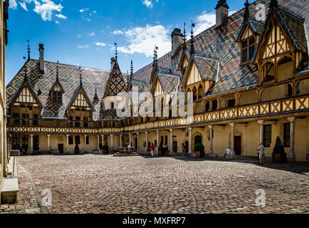 Innenhof und burgundischen Ziegeldach von Hospice de Beaune in Beaune, Burgund, Frankreich am 17. Juni 2018 getroffen Stockfoto