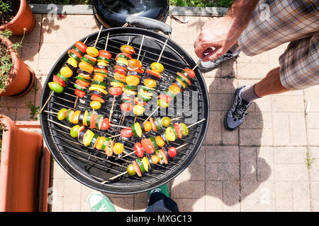 Kochen und Grillen Gemüse - Zucchini Tomaten und pepeer-Spieße auf dem Grill draußen ein sonniges entspanntes Wochenende Stockfoto