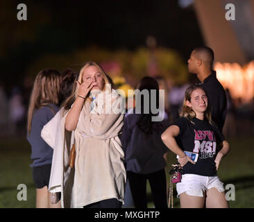 Parkland, FL, USA. 16 Feb, 2018. Ein junger Frauen Orte Blumen an einer Gedenkstätte, ehrt die Opfer der Masse schießen auf Marjory Stoneman Douglas High School, At Pine Trail Park am 16. Februar in Parkland, Florida 2018. Polizei verhaftet 19-jährigen ehemaligen Schüler Nikolas Cruz für die Ermordung von 17 Personen an der High School. Personen: Atmosphäre Credit: Hoo Me.Com/Media Punch/Alamy leben Nachrichten Stockfoto