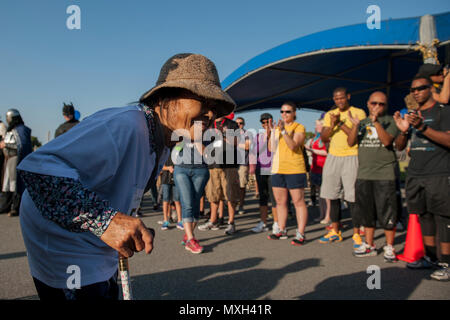 Eiko, Kadena Special Olympics Athlet, erhält Grüße und Prost von Freiwilligen während der Athlet Anreise Veranstaltung Nov. 5, 2016, bei Kadena Air Base, Japan. Rund 1.000 amerikanische Freiwillige mit mehr als 500 lokalen Dolmetscher gepaart KSO Athleten, die von sechs bis 95 Jahren reichten zu unterstützen. (U.S. Air Force Foto von älteren Flieger Peter Reft/Freigegeben) Stockfoto