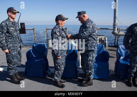 161105-N-N 0901-108 MITTELMEER (Nov 5, 2016) - Kapitän reichen Dromerhauser, Commodore, Destroyer Squadron 60, rechts, Stifte a Meritorious Service Medal auf Cmdr. Ken Pickard, kommandierender Offizier, USS Carney (DDG64), während eine Änderung der Befehl Zeremonie an Bord der USS Carney, Nov. 5, 2016. Carney, einem der Arleigh-Burke-Klasse geführte-missile Destroyer, Vorwärts - Rota, Spanien bereitgestellt werden, ist die Durchführung einer Routinepatrouille in den USA 6 Flotte Bereich der Maßnahmen zur Unterstützung der US-amerikanischen nationalen Sicherheitsinteressen in Europa. (U.S. Marine Foto von Petty Officer 2. Klasse Ramiro Flores/Freigegeben) Stockfoto