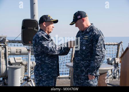 161105-N-N 0901-118 MITTELMEER (Nov 5, 2016) - Cmdr. Ken Pickard, Links, Stifte einen Befehl auf See Pin auf Cmdr. Peter Halvorsen, kommandierender Offizier, USS Carney (DDG64) bei einem Befehl Zeremonie an Bord an Bord der USS Carney, Nov. 5, 2016. Carney, einem der Arleigh-Burke-Klasse geführte-missile Destroyer, Vorwärts - Rota, Spanien bereitgestellt werden, ist die Durchführung einer Routinepatrouille in den USA 6 Flotte Bereich der Maßnahmen zur Unterstützung der US-amerikanischen nationalen Sicherheitsinteressen in Europa. (U.S. Marine Foto von Petty Officer 2. Klasse Alex Walsh/Freigegeben) Stockfoto