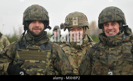 1. Lt. Claire Vanderberg, Mörtel Zugführer zur 6. Staffel zugeordnet, 8 Kavallerie Regiments, 2 Infantry Brigade Combat Team, 3rd Infantry Division posiert für ein Foto mit polnischen Lehrern während einer direkten legen Training live-fire Übung mit ukrainischen Soldaten auf das erste Bataillon zugeordnet, 80 Airmobile Brigade an der internationalen Friedenssicherung und Security Center. Das Training war Teil einer 9-wöchigen Ausbildung Rotation mit der Gemeinsamen multinationalen Ausbildung Group-Ukraine, die mit individuellen Fähigkeiten beginnt, wie die verschiedenen Taktiken mit Mörtel Training verwendet, und baut bis zu c Stockfoto