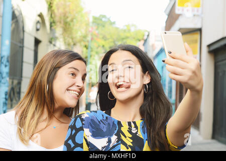 Zwei schöne junge Frauen, die selfie und Grimassen. Lifestyle und Freundschaft Konzepte. Stockfoto