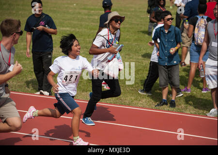 Während der Kadena Special Olympics auf der Kadena Air Base, Japan, nahmen Athleten an einem 100-Meter-Dash-Event teil. Die Spiele, die erstmals 2000 stattfanden, konzentrieren sich auf die Förderung von Inklusion, Teamgeist, Mut und Engagement in der Gemeinschaft. Freiwillige, Familienmitglieder und Teilnehmer aus den USA und Japan unterstützen die Veranstaltung. Die Special Olympics bieten Athleten mit besonderen Bedürfnissen sinnvolle Möglichkeiten, um in der gesamten Region Okinawa zu konkurrieren, Fähigkeiten zu entwickeln und Verständnis und Akzeptanz zu fördern. Stockfoto