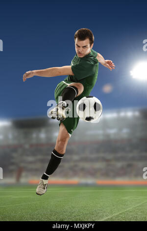 Fußball-Spieler kicken den Ball in einem Stadion bei Nacht Stockfoto