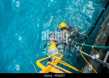 Chief Petty Officer Dan Luberto, rechts, und Petty Officer 2. Klasse Casey Campbell, beide zugeordnet zu Unterwasser Bau Team (UCT) 2 Bau Dive Loslösung Bravo (CDDB), erwarten Anweisungen, um das Wasser zu verlassen, nachdem Sie einen Tauchgang in Diego Garcia, Britisches Territorium im Indischen Ozean, Nov. 10, 2016. CDDB ist die Präzision unter Wasser Abriss und leichten Bergung Sprühbehinderungen von Diego Garcia ist tief Entwurf Wharf zu entfernen. CDDB ist auf der dritten Haltestelle Ihrer Bereitstellung, in dem Sie die Inspektion, Wartung und Reparatur der verschiedenen Unterwasser- und Waterfront Einrichtungen whil Stockfoto