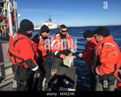 Petty Officer 3. Klasse Michael Bashe erklärt Maine Marine Patrouille Offiziere, was in einem lebenden Meeresressourcen boarding Kit am Donnerstag, November 10, 2016. Mannschaften von Coast Guard Cutter Escanaba, Station Southwest Harbor und Maine Marine Patrol sammeln Gemeinsame boardings aus Maine Küste im Betrieb blau Klaue zu führen. (U.S. Coast Guard Foto von Petty Officer 2. Klasse Curtis Bethea) Stockfoto