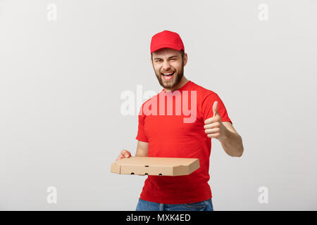 Pizza Delivery Konzept. Junge schöne Delivery Man, pizza box und halten den Daumen oben unterzeichnen. Auf weissem Hintergrund Stockfoto