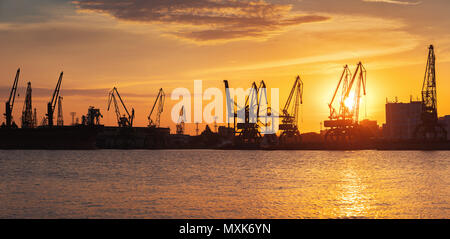 Farbenfroher Sonnenuntergang über Hafen und Industriekrane, Varna, Bulgarien Stockfoto