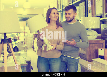 Junges Paar Auswahl Tischleuchte für Wohnung in Möbeln store Stockfoto