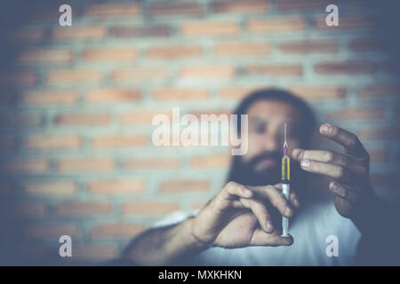 Drogensüchtigen Mann mit Spritze mit Drogen, Drogen Konzept. Stockfoto