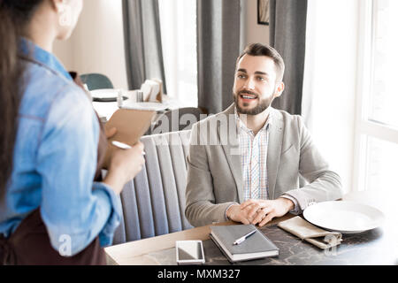 Positive Geschäftsmann, Bestellung im Restaurant Stockfoto