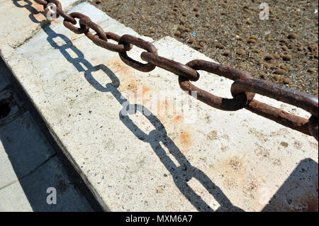 Starke, kräftige, rostige Kette Schuß von oben im Sonnenlicht. Schatten von der Kette. Stockfoto