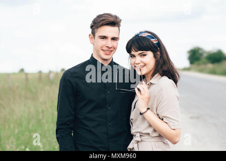 Nette junge Mann stand neben einem schönen Mädchen auf einem grünen Hintergrund hinter einer Stadt Stockfoto