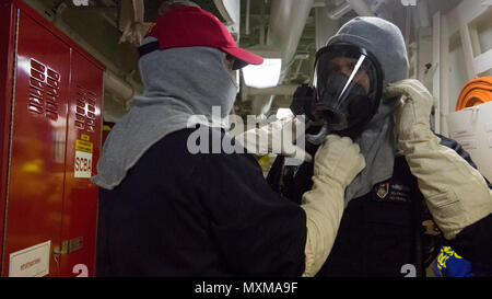 161114-N-HV 059-027 karibische Meer (Nov. 14, 2016) eine Schadensbegrenzung Training Team Mitglied stellt die flash Haube getragen von Petty Officer 1st Class Vasyl Bilokonsky während eines General Quarters durchgeführten an Bord der USS Zumwalt (DDG 1000). Mit Crew von 147 Segler, Zumwalt ist das Typschiff einer Klasse von Zerstörern der nächsten Generation konzipiert Seemacht, indem Sie kritische Missionen und die Verbesserung der US-Abschreckung, die Projektion und das Meer steuern Ziele zu stärken. (U.S. Marine Foto von Petty Officer 2. Klasse Sonja Wickard/Freigegeben) Stockfoto