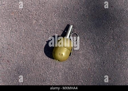 Grüne Granate ruht auf einem Schlachtfeld. Handgranate RGD-5 auf Asphalt. Verloren grünen Granat. echte Waffen sind gefährlich, splittergranate. Stockfoto