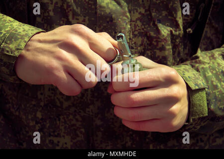 Granate, Hände auf Pin. der Soldat zieht einen Scheck von einer splittergranate RGD-5. Self-Explosion. Stockfoto