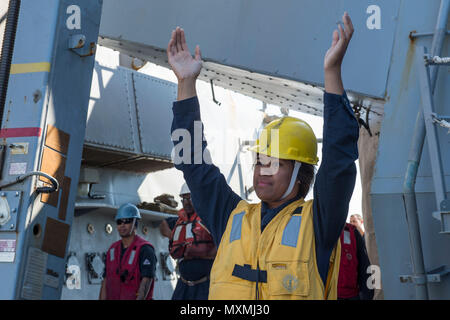 161106-N-YB 832-054 philippinischen Meer (Nov. 6, 2016) Seaman kostbare Aumua, der Arleigh-burke-Klasse geführte Anti-raketen-Zerstörer USS Curtis Wilbur (DDG54), Signale der militärischen Sealift Command (MSC) Lewis und Clark-Klasse Dry Cargo ship USNS Charles Drew (T-AKE-10) während einer laufenden Replenishment (Unrep). Curtis Wilbur ist auf Patrouille im philippinischen Meer Unterstützung der Sicherheit und Stabilität in der Indo-Asia-Pazifik-Region. (U.S. Marine Foto von Petty Officer 3. Klasse Ellen Hilkowski/Freigegeben) Stockfoto