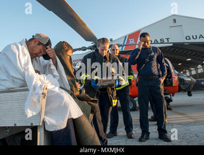 Crew Mitglieder aus St. Petersburg, Florida Feuerwehr drei Fischer, die aus einem versunkenen Schiff ca. 35 km südwestlich von Cape San Blas, Florida, Mittwoch, November 23, 2016 gerettet wurden. Die Fischer waren, Coast Guard Air Station Clearwater von einem MH-60 Jayhawk Helikopter Crew, wo Sie mit dem EMS met geflogen, keine Verletzungen zu berichten. U.S. Coast Guard Foto von Petty Officer 1st Class Michael De Nyse. Stockfoto