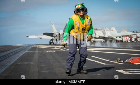 161116-N-BL 637-060 PAZIFISCHEN OZEAN (Nov. 16, 2016) Petty Officer 2nd class Mario Otero erholt sich nach das Signal gegeben, eine F/A-18E Super Hornet von Strike Fighter Squadron (VFA) 192 "goldenen Drachen" auf dem Flugzeugträger USS Carl Vinson (CVN 70) Flight Deck zu starten. Die Carl Vinson Strike Group ist derzeit die Durchführung von Composite Trainingsgerät Übung in Vorbereitung für eine bevorstehende Bereitstellung. (U.S. Marine Foto von Petty Officer 3. Klasse Sean M. Castellano/Freigegeben) Stockfoto