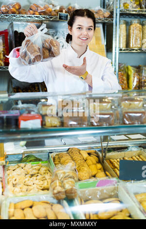 Junge freundliche Frau Verkauf von Cookies und anderen Füllungen Stockfoto