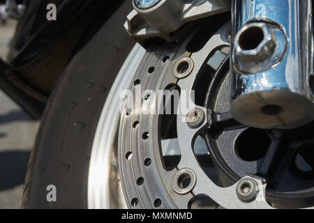 Nahaufnahme der vorderen Rad Motorrad Bremsscheibe. Die Schraube beginnt zu korrodieren, eine Gefahr für die Sicherheit im Straßenverkehr Stockfoto