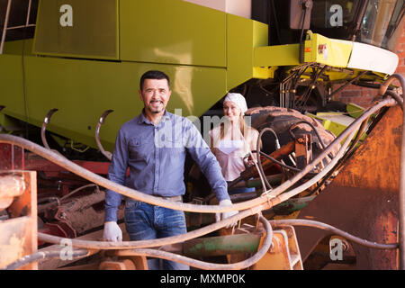 Lächelnd Mann und Frau Bauern neben großen Feld Motor und Reden Stockfoto