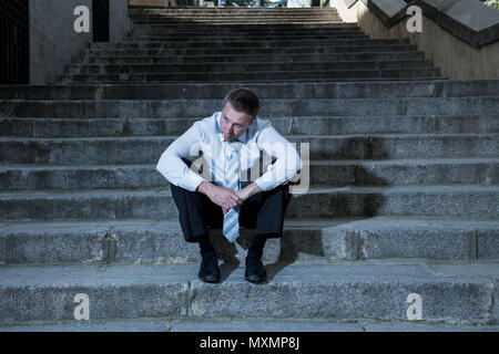 Young Business Mann in Depressionen sitzen auf der Straße Treppen leiden emotionale Schmerzen aufgegeben verloren weinend, Traurigkeit in einem seelischen Konzept Foto Stockfoto