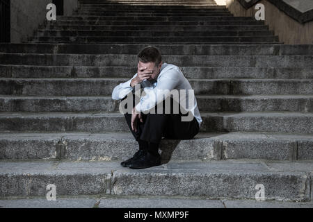 Young Business Mann in Depressionen sitzen auf der Straße Treppen leiden emotionale Schmerzen aufgegeben verloren weinend, Traurigkeit in einem seelischen Konzept Foto Stockfoto