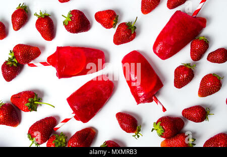 Frische Erdbeeren Popsicle auf weißem Hintergrund der Ansicht von oben Stockfoto